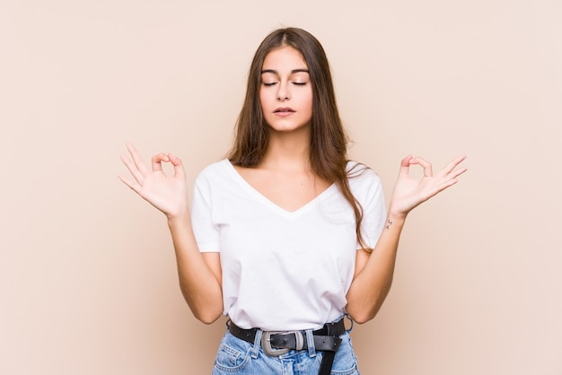 Jovem mulher caucasiana posando isolada relaxa após um árduo dia de trabalho, ela está realizando ioga.