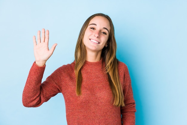 Jovem mulher caucasiana posando isolado sorrindo alegre mostrando o número cinco com os dedos.