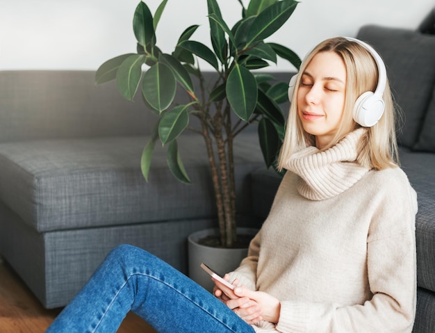 Jovem mulher caucasiana relaxa em casa com música