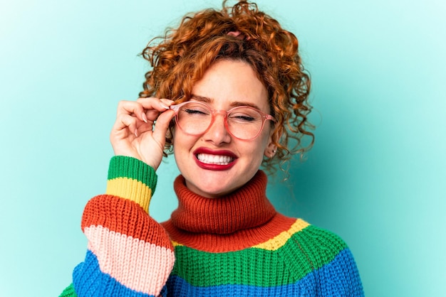 Jovem mulher caucasiana ruiva isolada em fundo azul