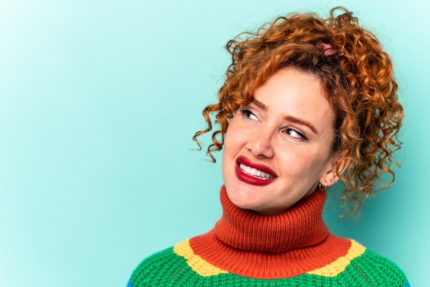 Jovem mulher caucasiana ruiva isolada em fundo azul