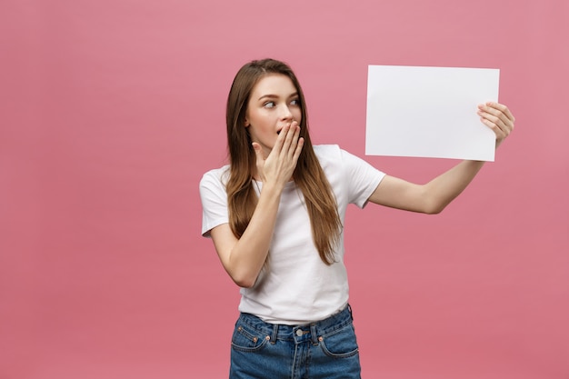 Jovem mulher caucasiana, segurando a folha de papel em branco