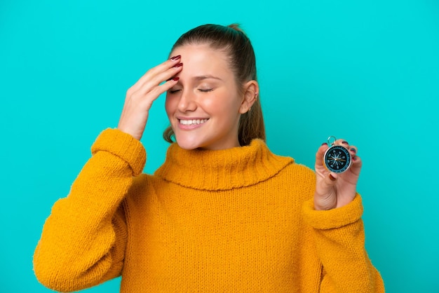 Foto jovem mulher caucasiana segurando bússola isolada em fundo azul percebeu algo e pretende a solução