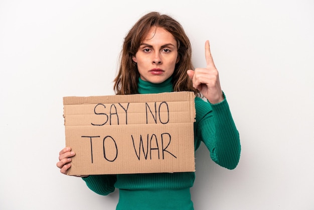 Jovem mulher caucasiana segurando dizer sem cartaz de guerra isolado no fundo branco