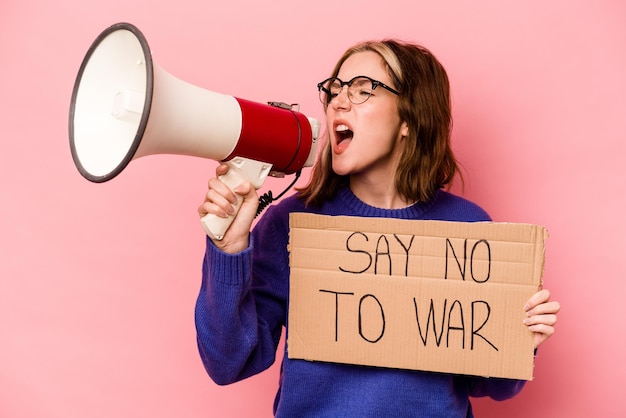 Jovem mulher caucasiana segurando nenhum cartaz de guerra isolado em fundo rosa