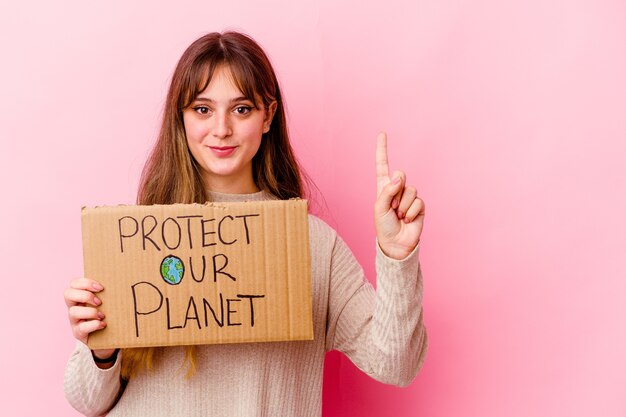 Jovem mulher caucasiana segurando o cartaz de proteger nosso planeta isolado