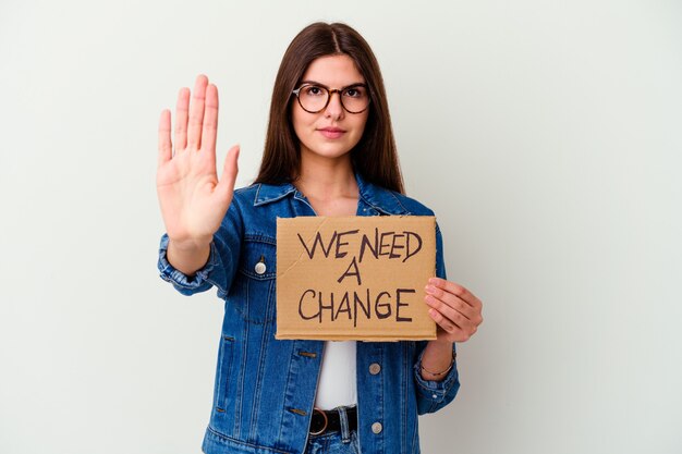 Jovem mulher caucasiana segurando proteger nosso cartaz de planeta apontando com o dedo para você como se fosse um convite para se aproximar.