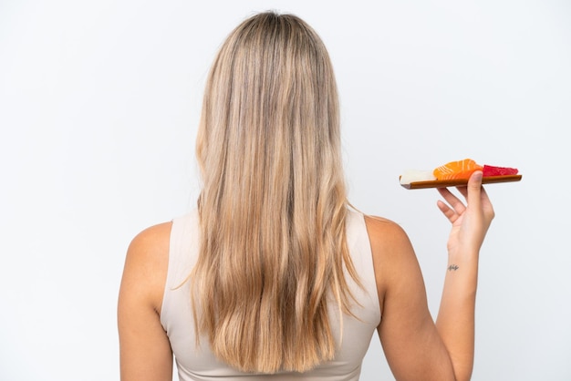 Jovem mulher caucasiana segurando sashimi isolado no fundo branco na posição traseira