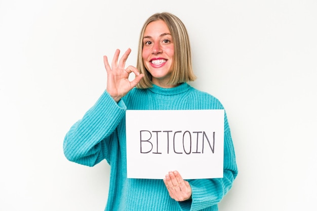 Jovem mulher caucasiana segurando um cartaz de bitcoin isolado no fundo branco