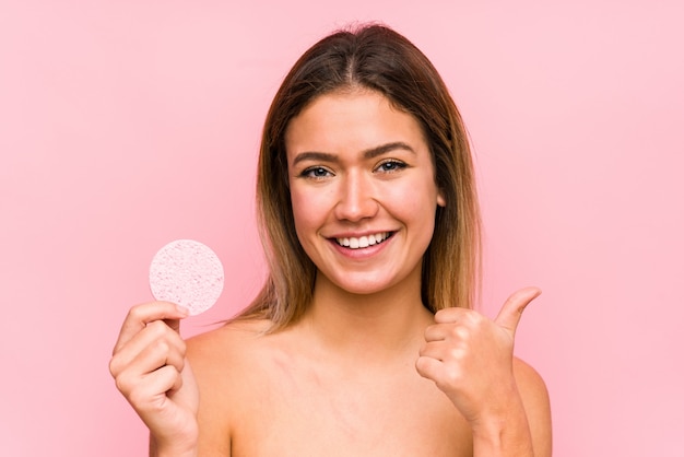 Jovem mulher caucasiana, segurando um disco facial isolado sorrindo e levantando o polegar