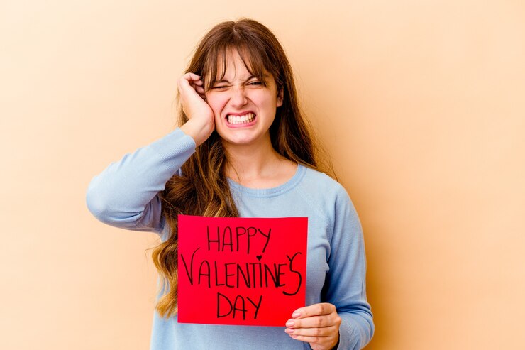 Foto jovem mulher caucasiana, segurando um feliz dia dos namorados isolado cobrindo as orelhas com as mãos.