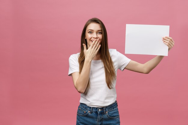 Jovem mulher caucasiana segurando um papel em branco