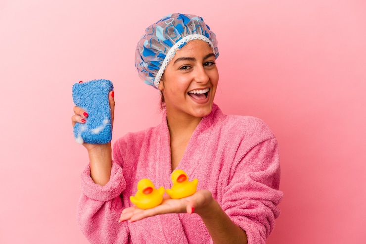 Foto jovem mulher caucasiana segurando um pato de plástico isolado em um fundo rosa