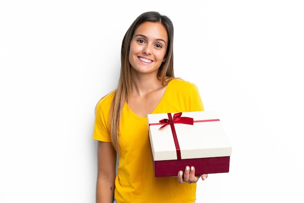 Jovem mulher caucasiana segurando um presente isolado no fundo branco sorrindo muito