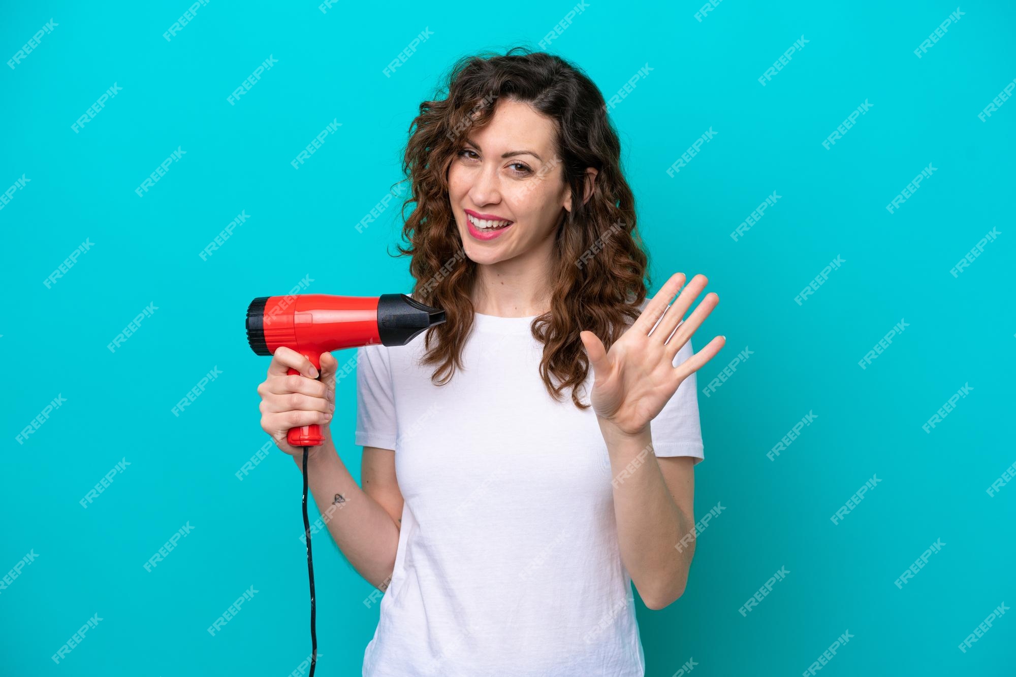 Mão segurando o secador de cabelo isolado no fundo branco