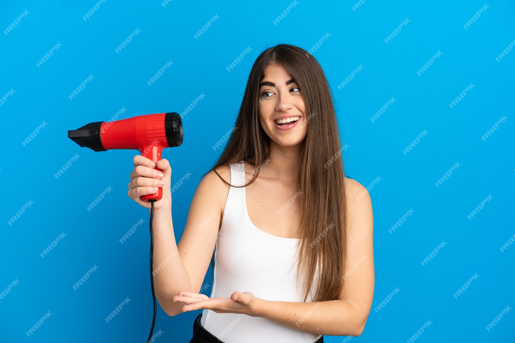 Mão segurando o secador de cabelo isolado no fundo branco