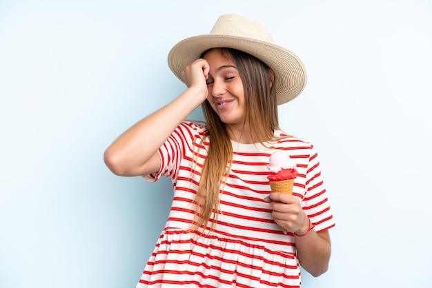 Jovem mulher caucasiana segurando um sorvete isolado em fundo azul percebeu algo e pretende a solução