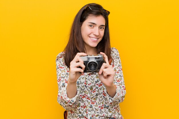 Jovem mulher caucasiana segurando uma câmera vintage