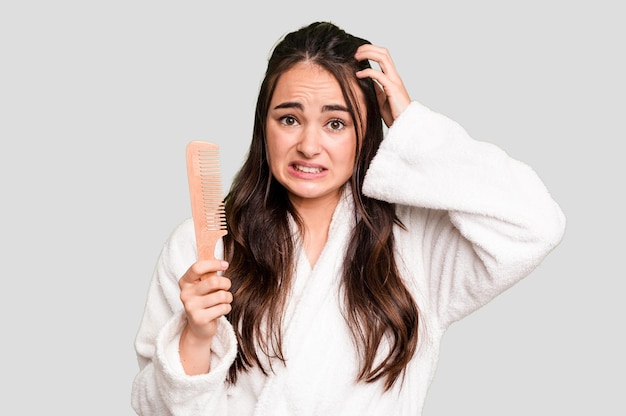 Foto jovem mulher caucasiana segurando uma escova de cabelo isolada