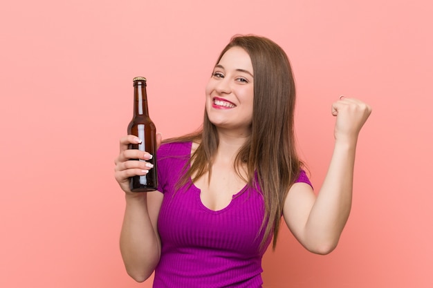 Jovem mulher caucasiana, segurando uma garrafa de cerveja