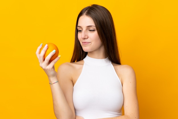 Jovem mulher caucasiana, segurando uma laranja isolada na laranja