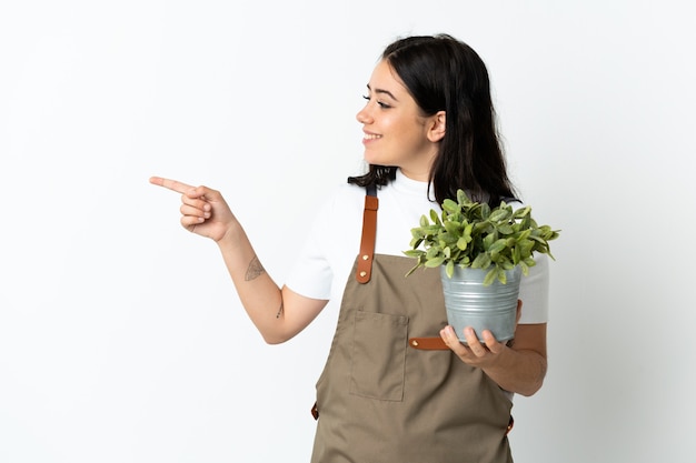 Jovem mulher caucasiana segurando uma planta isolada