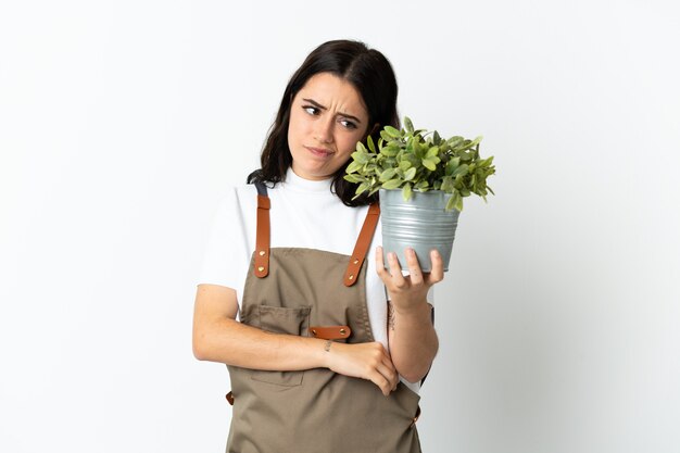 Jovem mulher caucasiana segurando uma planta isolada