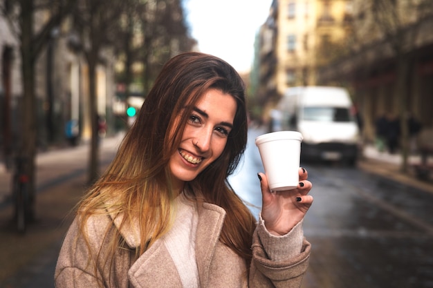 Jovem mulher caucasiana tomando um café take away enquanto caminhava pelo centro da cidade em Donostia-San Sebastian Basque Country.