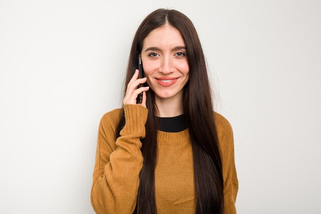 Jovem mulher caucasiana usando telefone celular isolado no fundo branco