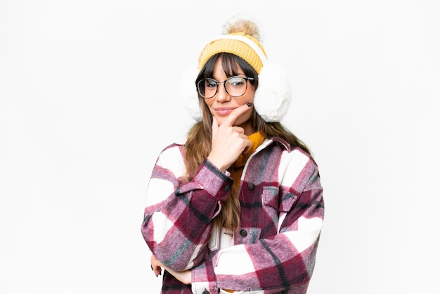 Jovem mulher caucasiana vestindo muffs de inverno sobre fundo branco isolado sorrindo