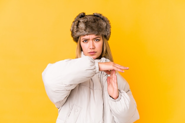 Jovem mulher caucasiana, vestindo roupas de inverno, mostrando um gesto de tempo limite.