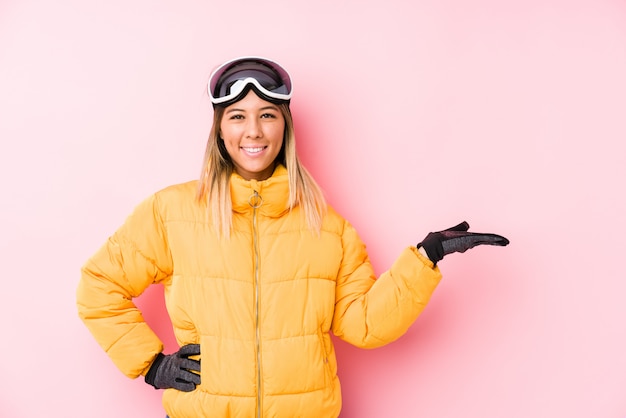 Jovem mulher caucasiana, vestindo uma roupa de esqui em rosa