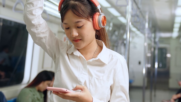 Jovem mulher celular no trem público Conceito de deslocamento diário do estilo de vida urbano da cidade