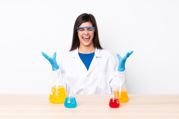 Jovem mulher científica em uma mesa sorrindo muito