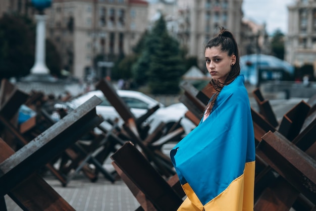 Jovem mulher coberta com a bandeira ucraniana