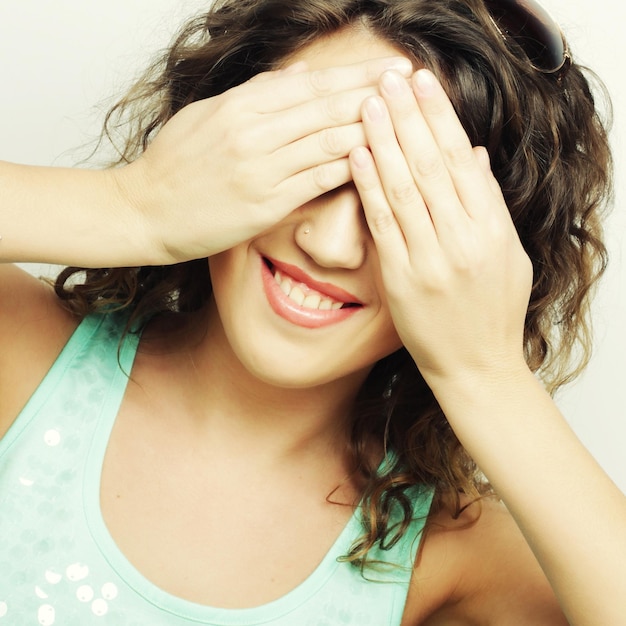 Jovem mulher cobrindo os olhos com as mãosStudio shot