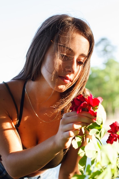 Jovem mulher colhendo uma rosa em um campo