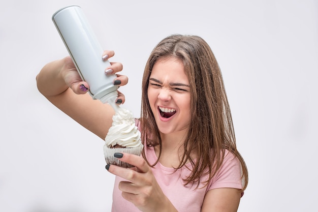 Jovem mulher colocar um pouco de creme em um bolinho