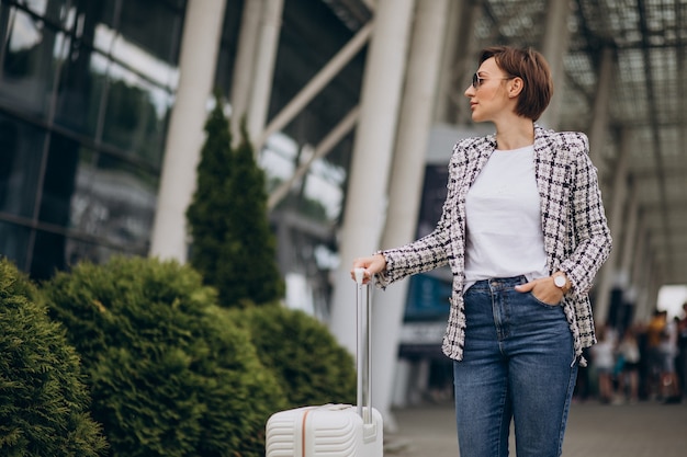 Jovem mulher com bagagem no aeroporto viajando