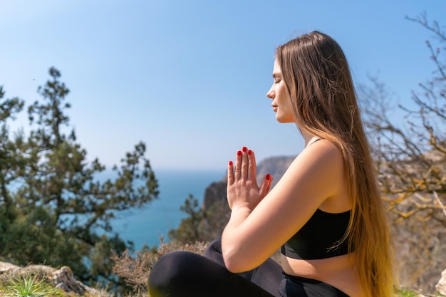 Jovem mulher com cabelo comprido, instrutor de fitness em leggings sportswear e tops alongamento antes