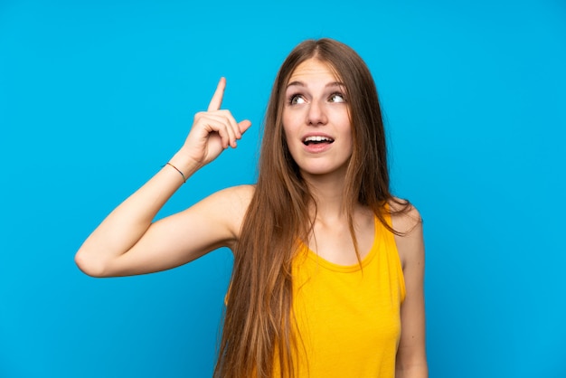 Jovem, mulher, com, cabelo longo, sobre, isolado, parede azul, pretendendo, para, perceba, a, solução, enquanto, levantamento, um, dedo cima