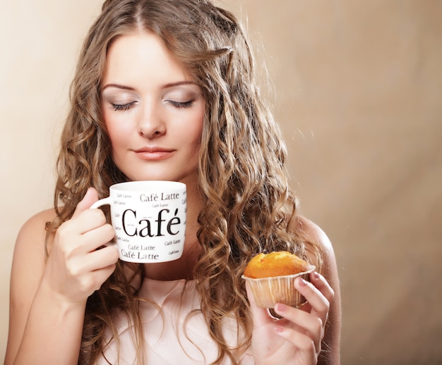 Jovem mulher com café e bolo