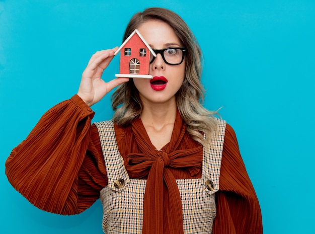 Jovem mulher com casa de brinquedo em azul