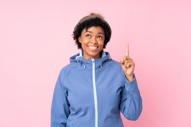 Jovem mulher com chapéu de inverno sobre parede isolada