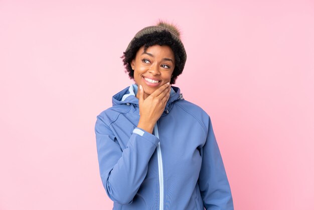 Jovem mulher com chapéu de inverno sobre parede isolada