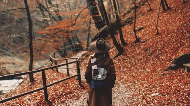 Jovem mulher com chapéu em um parque de temporada outono