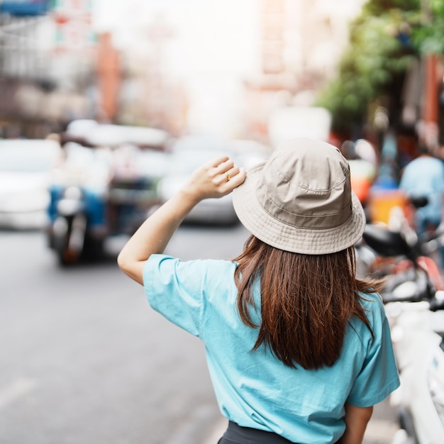 Jovem mulher com chapéu viajando em Bangkok Viajante asiático visitando a estrada Yaowarat ou Chinatown de Bangkok e popular para atrações turísticas na Tailândia Sudeste Asiático Conceito de viagem