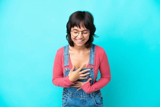 Jovem mulher com fundo isolado de macacão sorrindo muito