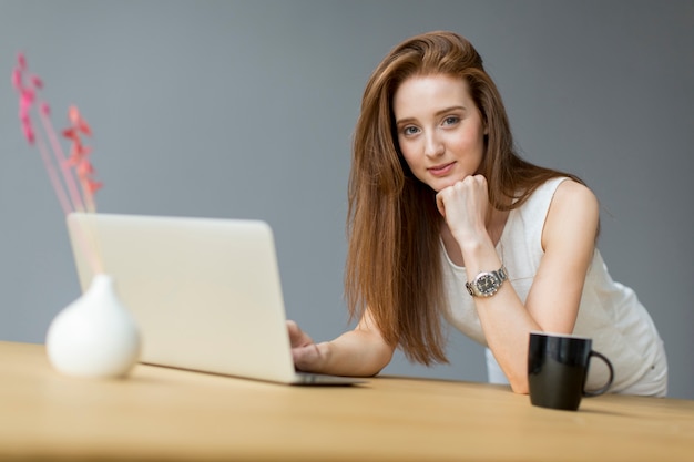 Jovem mulher com laptop no escritório