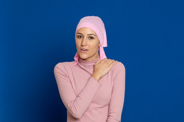 Jovem mulher com lenço rosa na cabeça em um azul